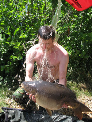 bucket of water tipped over bloke holding large carp